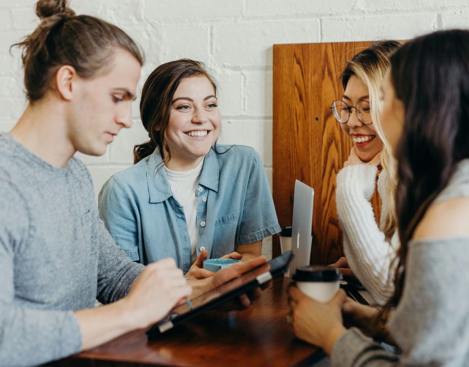 Personer sitter ned vid ett bord och pratar